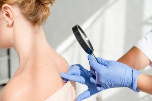 Dermatologist examining patient by mole mapping