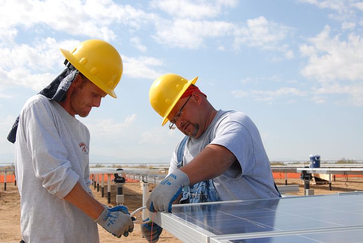 Two workers installing commercial solar